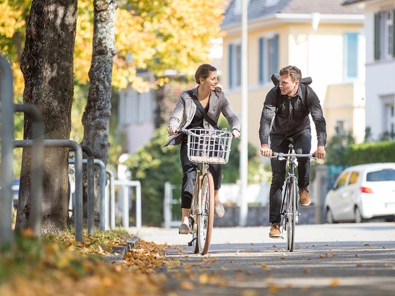 Zwei Radfahrer:innen fahren im Herbst zusammen Fahrrad Zwei Radfahrer:innen fahren im Herbst zusammen Fahrrad