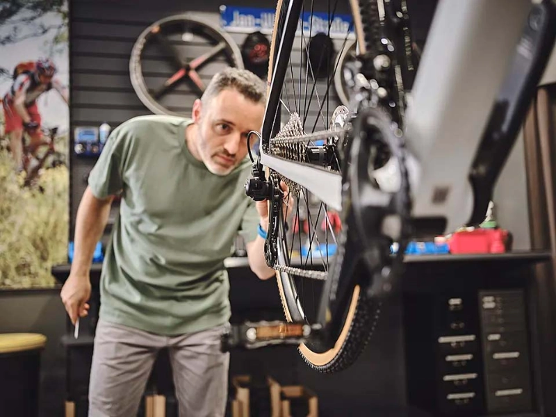 Ein Fachhändler blickt auf ein Hinterrad Ein Fachhändler blickt auf ein Hinterrad
